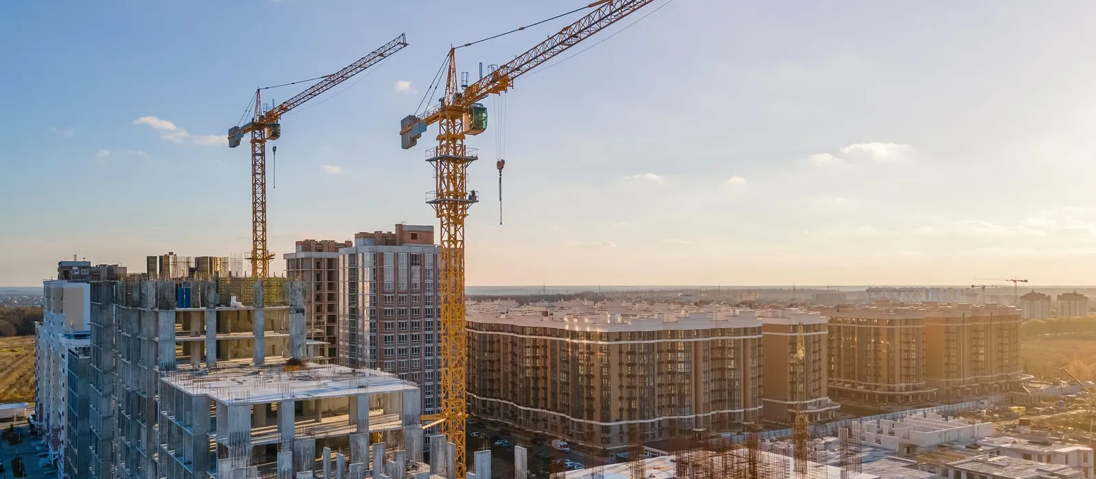 Cranes on a construction site surrounded by new buildings