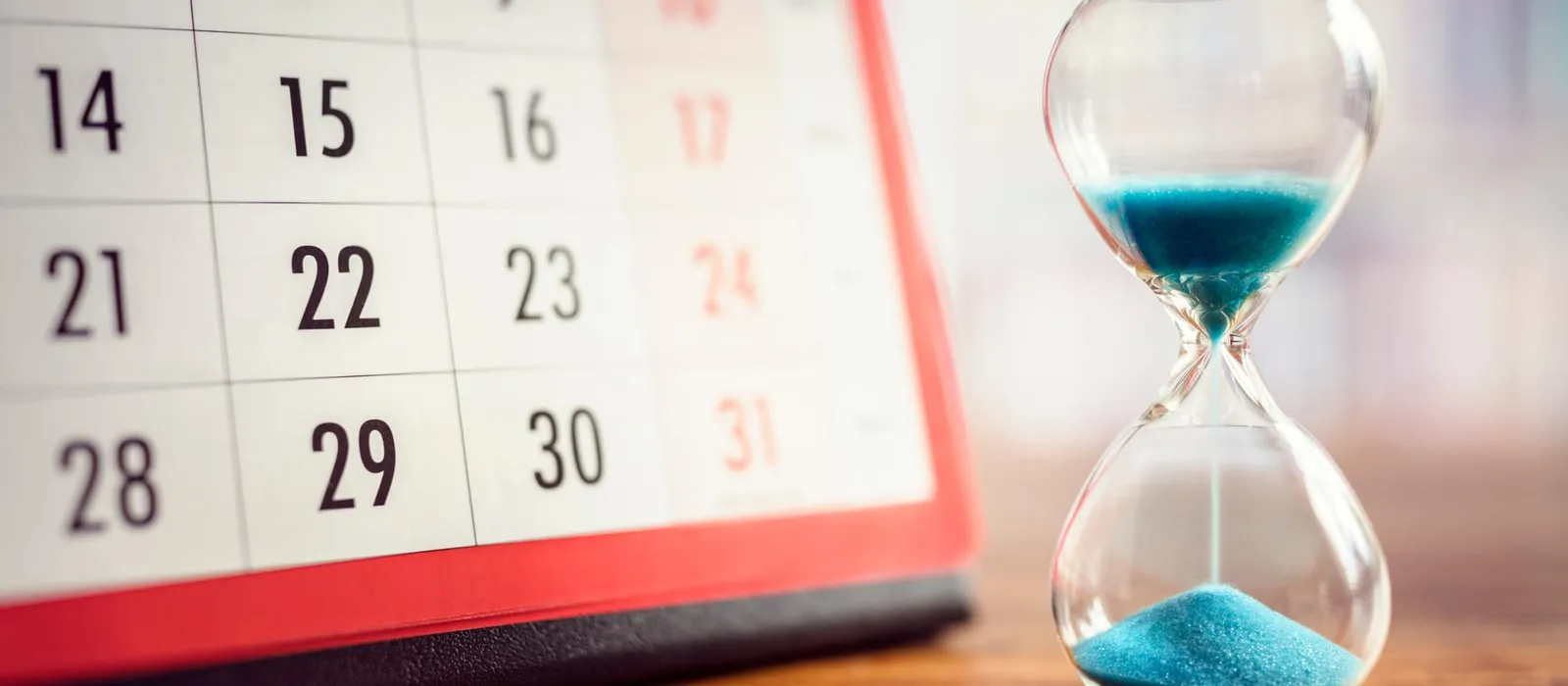 Hourglass standing on a calendar