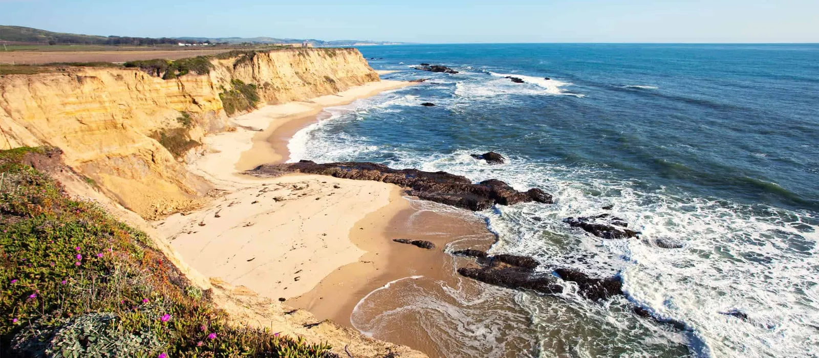 Sandy cove beneath coastal bluffs