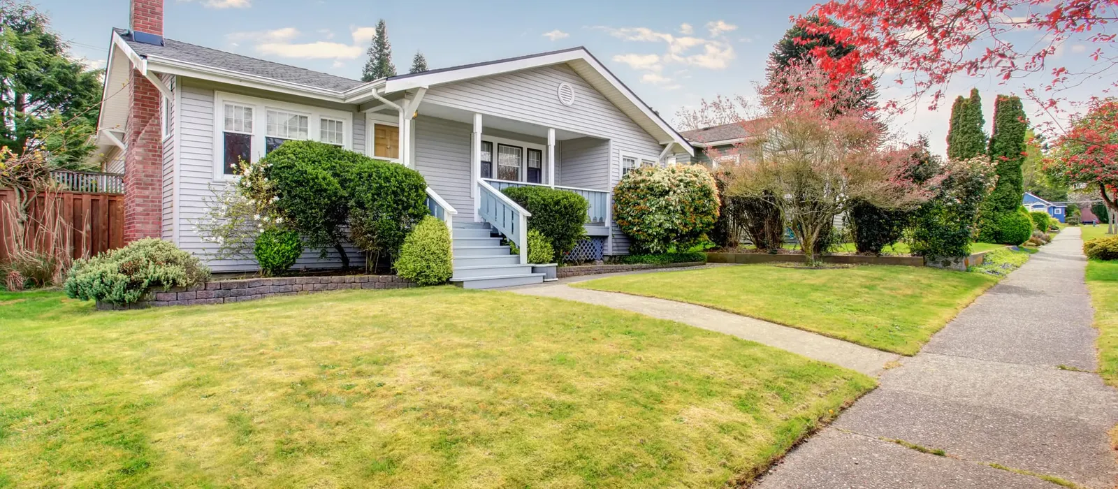 Beige siding house with a covered porch and lawn