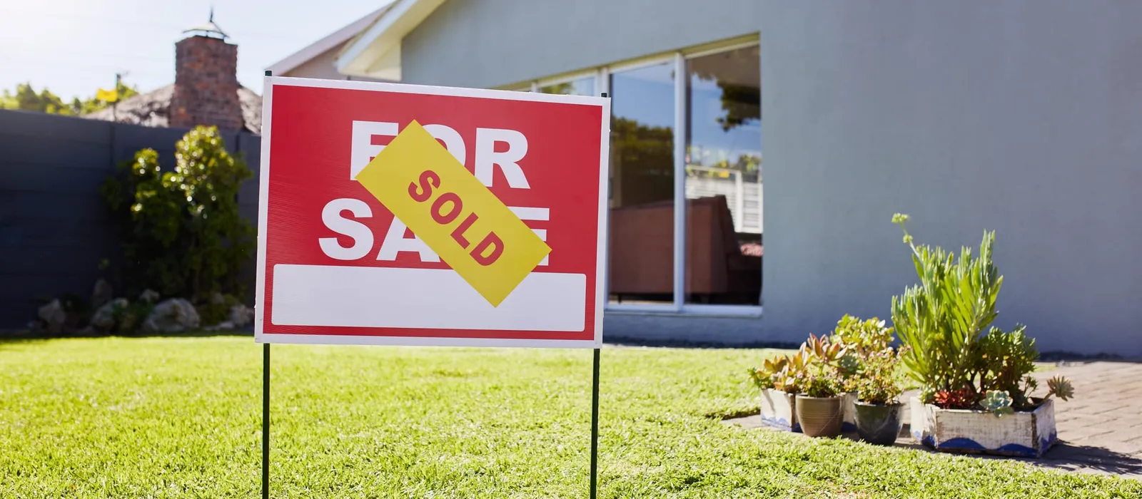 Sold sign in front of a modern suburban house