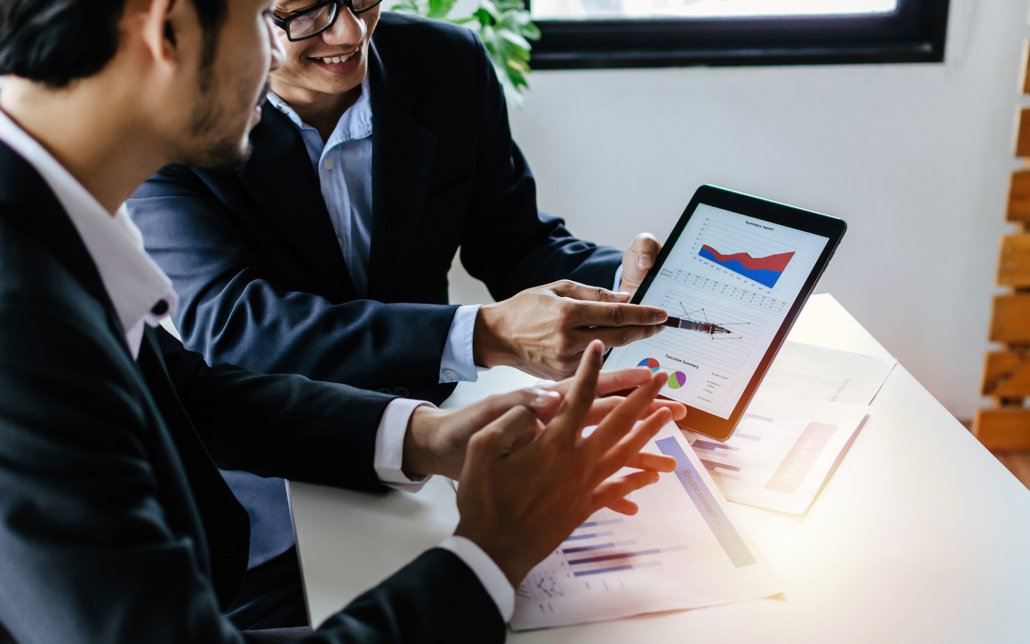 Two Business People Looking At Charts On Compiuter