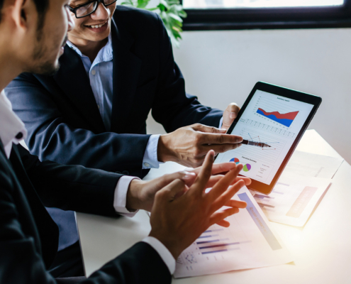 Two Business People Looking At Charts On Compiuter