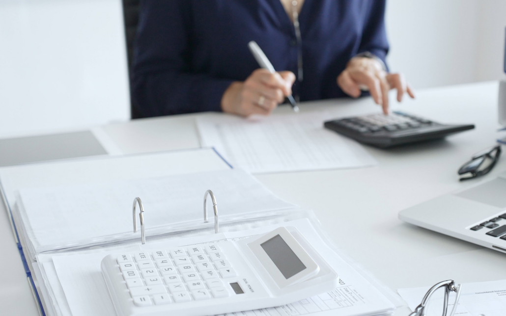 Person Using Calculator To Do Taxes